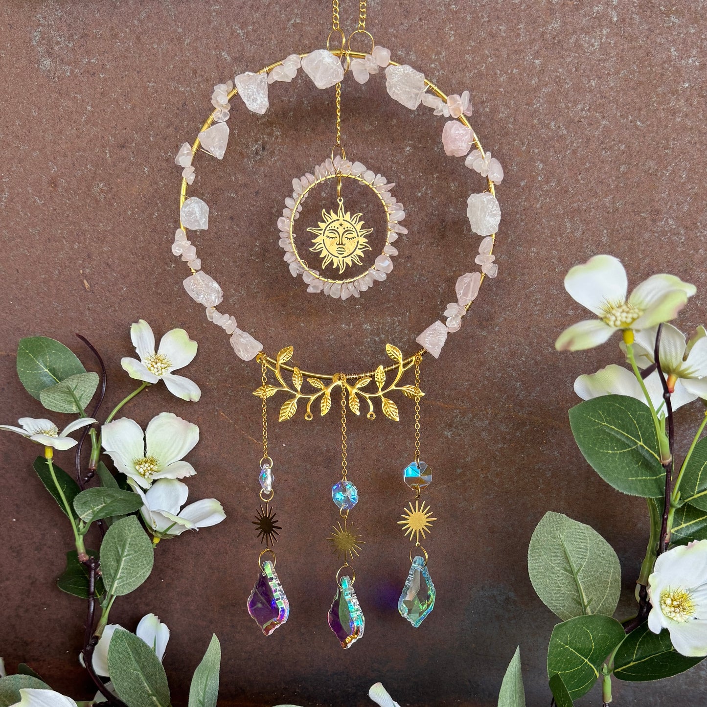 Decorative Crystal Sun Catcher - Rose Quartz hanging crystal wall art with sun and moon designs, surrounded by flowers and leaves.